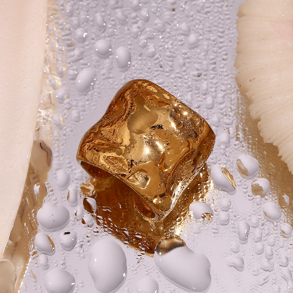 Niche minimaliste en acier inoxydable plaqué or 18 carats avec motif ondulé.