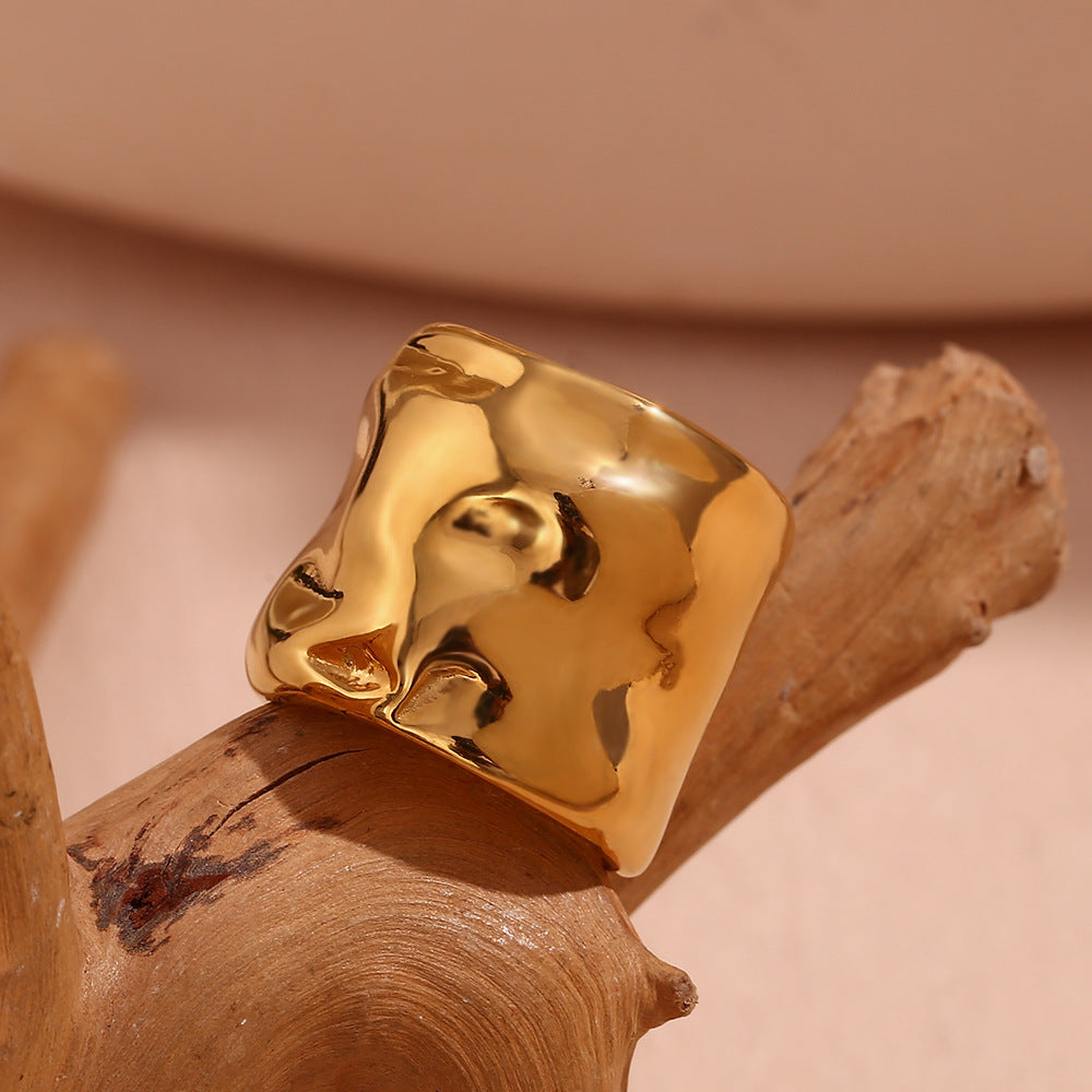 Niche minimaliste en acier inoxydable plaqué or 18 carats avec motif ondulé.