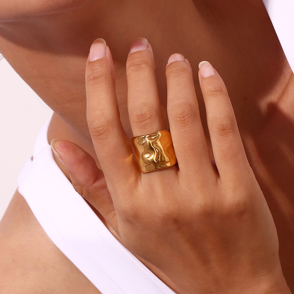 Niche minimaliste en acier inoxydable plaqué or 18 carats avec motif ondulé.