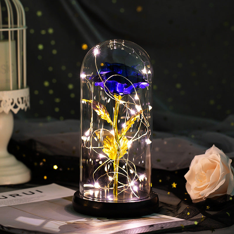 Fleur de rose éternelle enchantée dans une décoration de Noël lumineuse à LED en verre