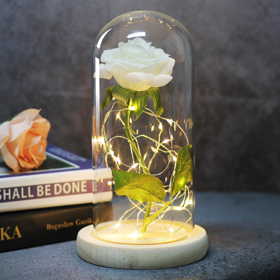 Fleur de rose éternelle enchantée dans une décoration de Noël lumineuse à LED en verre