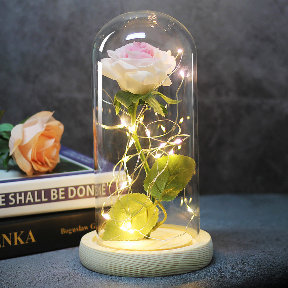 Fleur de rose éternelle enchantée dans une décoration de Noël lumineuse à LED en verre