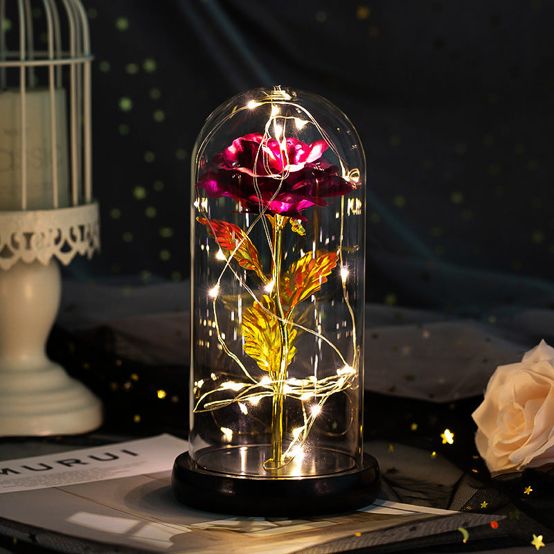 Fleur de rose éternelle enchantée dans une décoration de Noël lumineuse à LED en verre