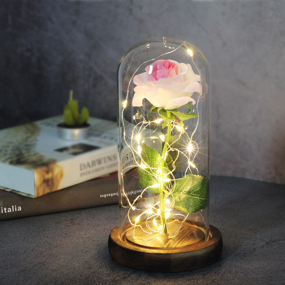 Fleur de rose éternelle enchantée dans une décoration de Noël lumineuse à LED en verre