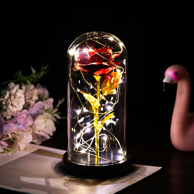 Fleur de rose éternelle enchantée dans une décoration de Noël lumineuse à LED en verre