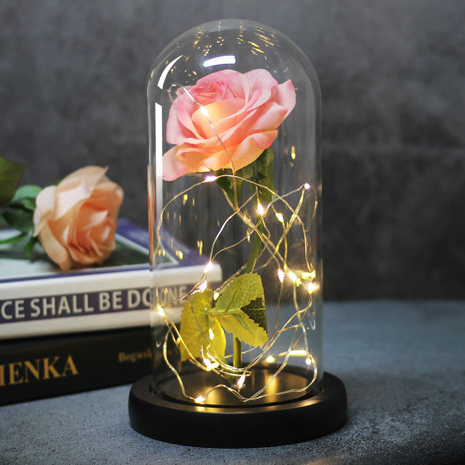 Fleur de rose éternelle enchantée dans une décoration de Noël lumineuse à LED en verre