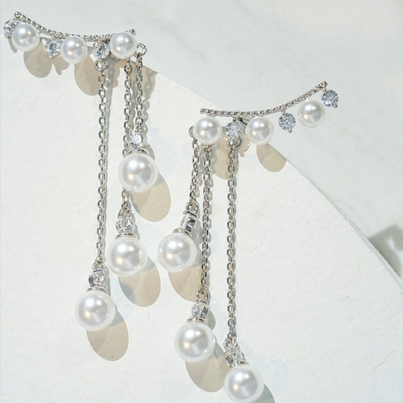 Pendiente largo con forma de gota y perla con borlas de perfil alto