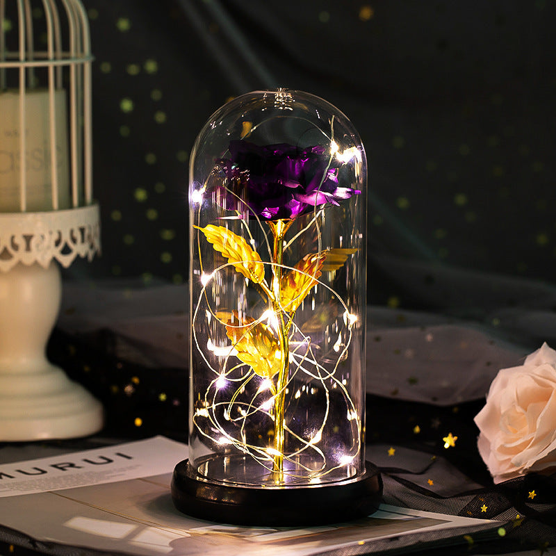 Fleur de rose éternelle enchantée dans une décoration de Noël lumineuse à LED en verre
