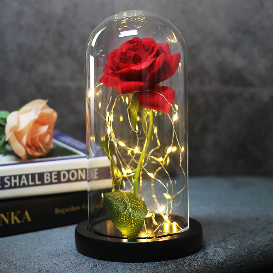 Fleur de rose éternelle enchantée dans une décoration de Noël lumineuse à LED en verre