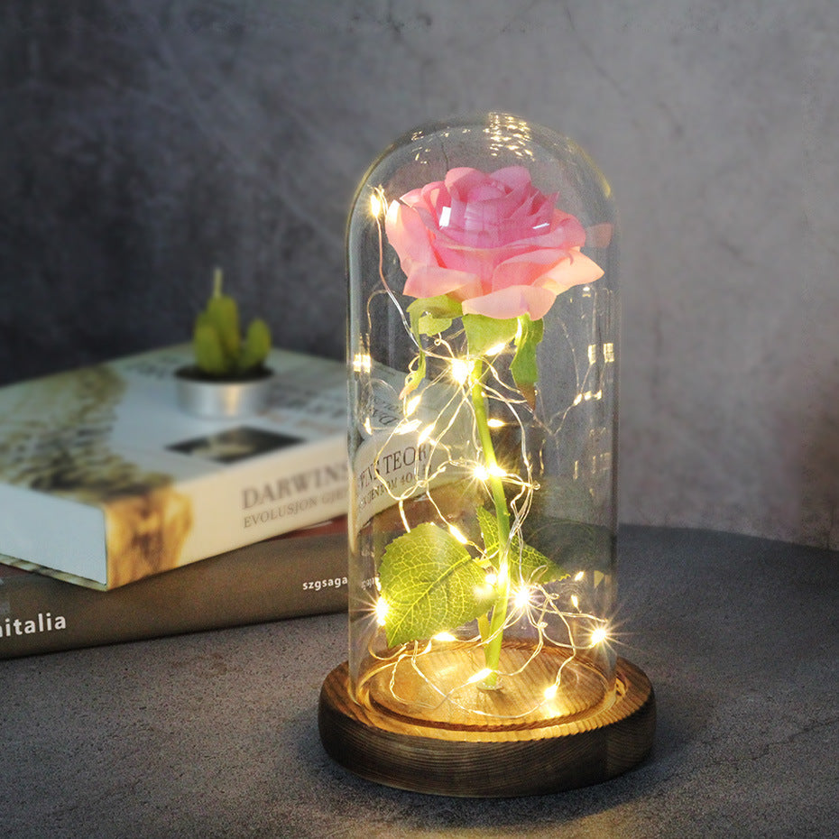 Fleur de rose éternelle enchantée dans une décoration de Noël lumineuse à LED en verre