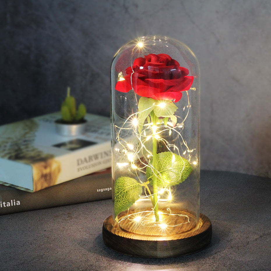 Fleur de rose éternelle enchantée dans une décoration de Noël lumineuse à LED en verre