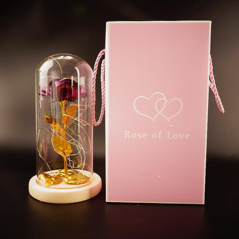 Fleur de rose éternelle enchantée dans une décoration de Noël lumineuse à LED en verre