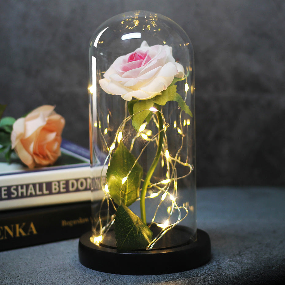 Fleur de rose éternelle enchantée dans une décoration de Noël lumineuse à LED en verre