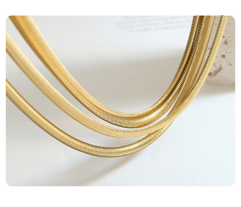 Collar de hueso de serpiente suave con costuras chapadas en oro con textura de metal