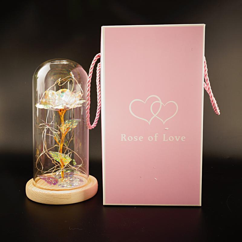 Fleur de rose éternelle enchantée dans une décoration de Noël lumineuse à LED en verre
