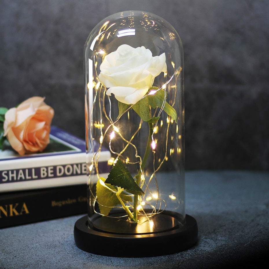 Fleur de rose éternelle enchantée dans une décoration de Noël lumineuse à LED en verre