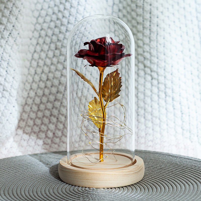 Fleur de rose éternelle enchantée dans une décoration de Noël lumineuse à LED en verre