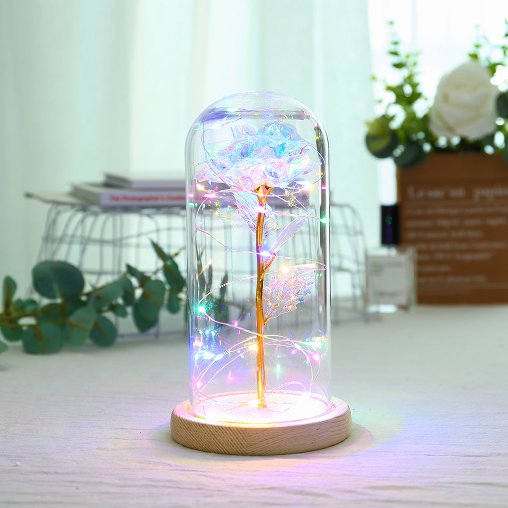 Fleur de rose éternelle enchantée dans une décoration de Noël lumineuse à LED en verre
