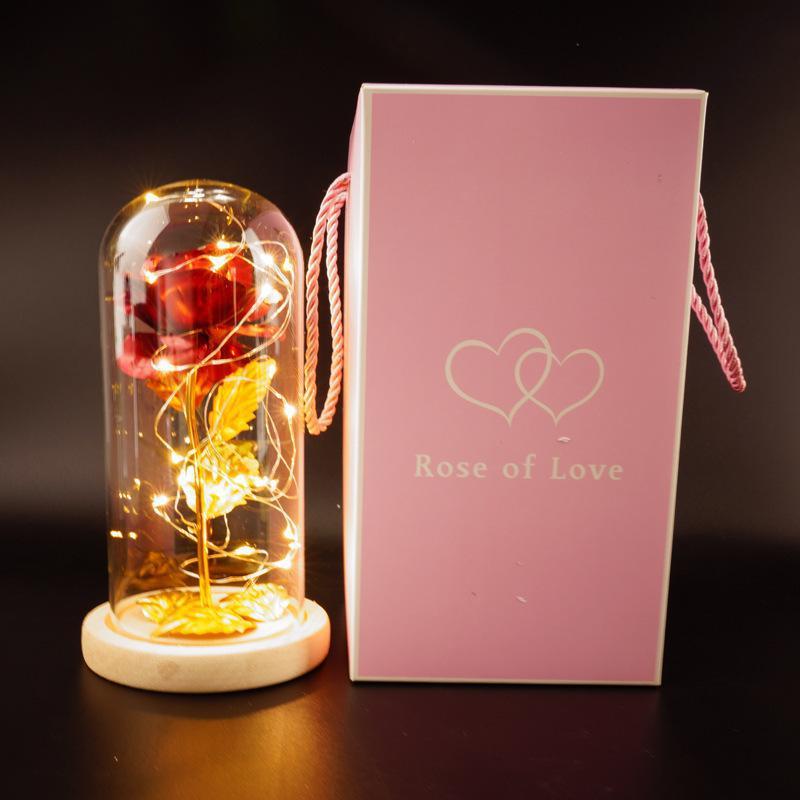 Fleur de rose éternelle enchantée dans une décoration de Noël lumineuse à LED en verre