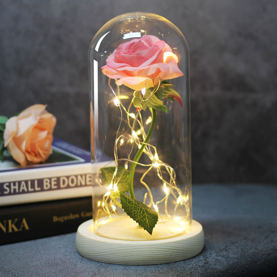 Fleur de rose éternelle enchantée dans une décoration de Noël lumineuse à LED en verre