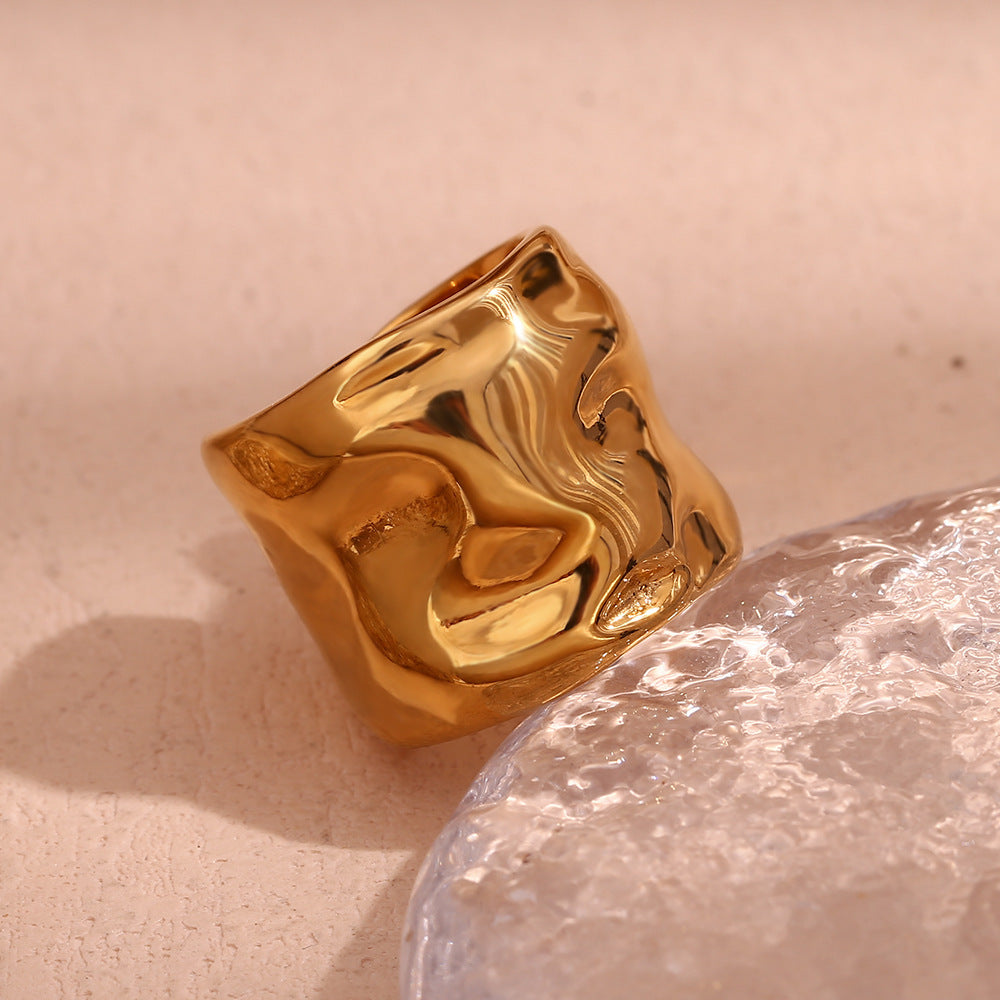 Niche minimaliste en acier inoxydable plaqué or 18 carats avec motif ondulé.